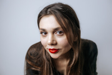 Portrait of a beautiful girl with red lips, big eyes and dark long hair