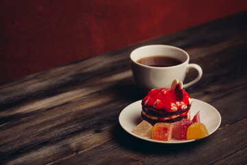 cup of tea red cake on a saucer sweets dessert wooden background