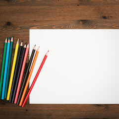 The sheet is pure white and colored pencils for drawing on a wooden background with a place to copy.