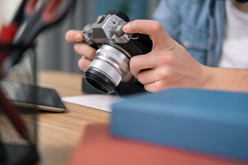 The hands of a teenager holding a camera.