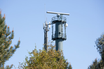 Coastal surveillance radar system on forest. Marine surveillance station. Copy space