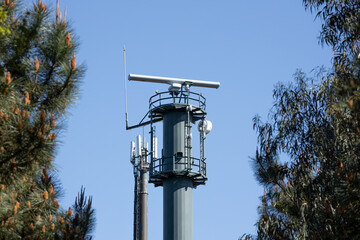 Coastal surveillance radar system on forest. Marine surveillance station. Copy space