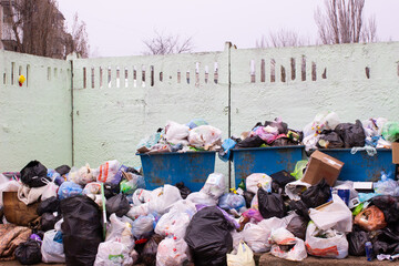 Full trash can. Trash can filled with trash. Trash can packed to overflowing with rubbish. The bin is filled with rubbish.