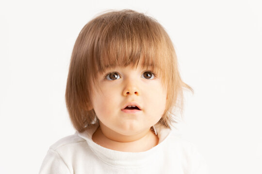 Close-up of a 1 year old baby boy with a Surprised face expression on white background.