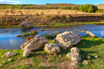 Limestone rocks on the river shore . Idyllic summer riverside nature