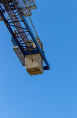 Concrete counterweights on tower crane to balance heavy load being lifted. Construction building...