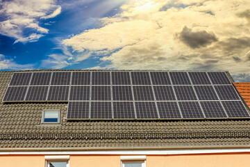 Mehrfamilienhaus mit Sonnenkollektoren unter dramatischem Himmel