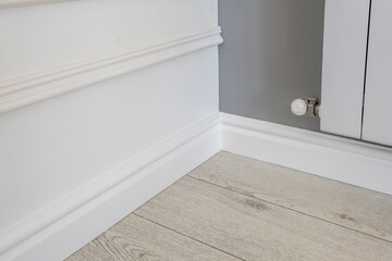 Detail of corner flooring with intricate crown molding and plinth.