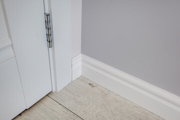 Detail of corner flooring with intricate crown molding and plinth.