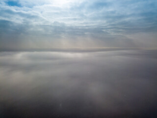 Fototapeta premium Aerial high view. Flying over the clouds.