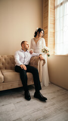 Obraz premium Husband and wife smiling happy couple hugging at the photo session studio. Wedding married bride and groom celebrate their engagement. Procreation romantic amazing lovers newlyweds indoor copy space 