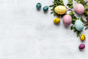 Frame of Easter eggs with spring branches and green leaves. Veiw from above