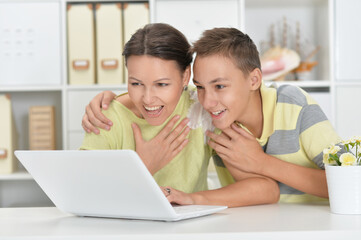 mother and son using modern laptop