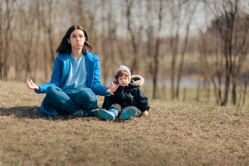 Fototapeta premium Mother in Lotus Pose Trying to Relax Outside