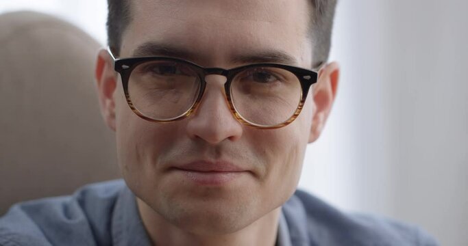 Close up of Attractive Businessman Face wears Eyeglasses looking at the Camera. Happy Smart Adult Man looking Confident wearing Casual clothes sitting at Office Room. Caucasian Appearance. Business.