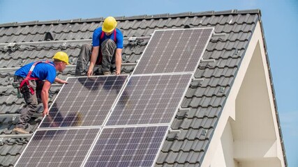 Workers installing alternative energy photovoltaic solar panels on the roof - Powered by Adobe