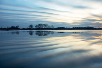 Fantastic clouds reflecting in the lake water after sunset