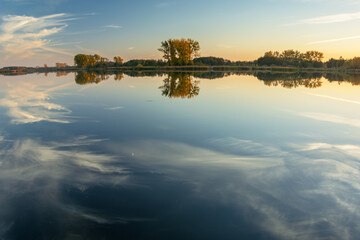 Reflection of white clouds in the water of a calm lake