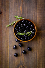 Black olives in wooden bowl. Overhead view