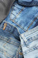 Fototapeta premium Top view of a pile of textured blue jeans, denim background.