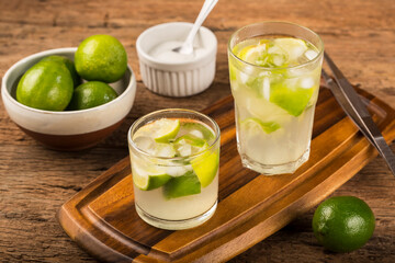 Brazilian Caipirinha. Cachaça drink with lemon, on rustic wooden background.