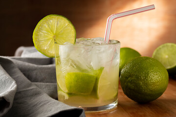 Brazilian Caipirinha. Cachaça drink with lemon, on rustic wooden background.