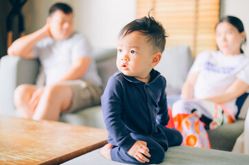Fototapeta premium childhood, sadness and people concept - sad boy and parents arguing at home