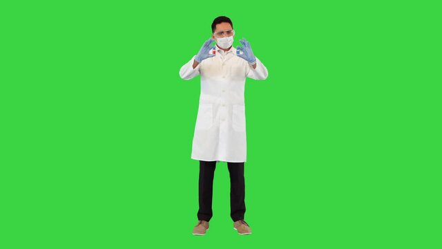 Which treatment, medicine or vaccine would you choose Doctor showing two ampoules with vaccines from covid-19 on a Green Screen, Chroma Key.