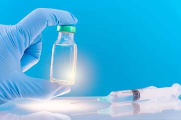 Potential trials stage concept on blue background. Close up Vials with sterile needle syringe. Research and Development, Vaccination.