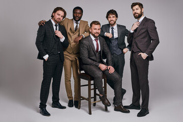 young male leaders in classic suit posing at camera in studio