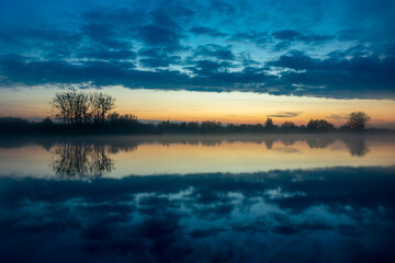 A mirror reflection of the evening clouds in the lake water