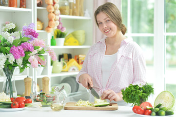 Obraz na płótnie Canvas teen girl preparing fresh salad