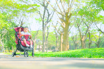 Mother walking with baby stroller in park