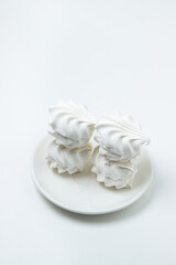 Marshmallow on a white background. White marshmallow on a white plate. Light dessert