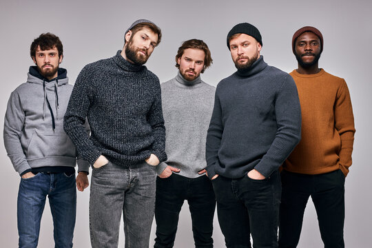group of young men in casual urban style outfits posing at camera