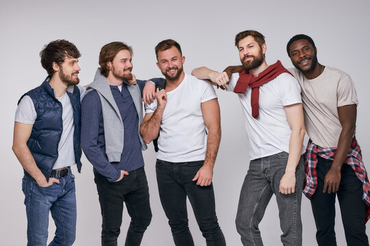 multi-ethnic group of men in casual urban style clothes posing at camera
