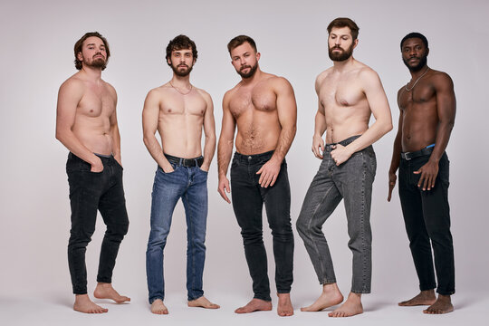 Portrait of shirtless diverse men posing seriously at camera, sexy guys in jeans