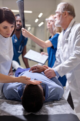 Obraz premium Team of doctors checking state of health of urgently admitted patient