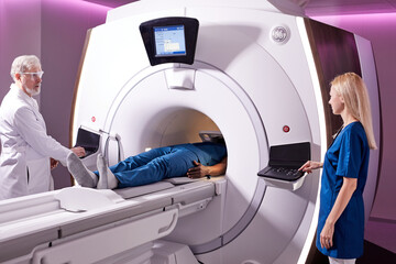 Medical technical assistant performing radiological scan of patient with magnetic resonance...