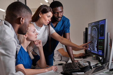 Multi-ethnic Group of Radiologists Discussing Diagnosis Using Monitors Showing Brain Scans Results