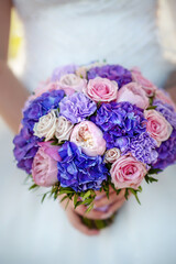 The bride holds a wedding bouquet in her hands