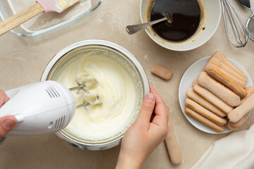 Mixing, whipping cream for cake. Cooking tiramisu cake with sponge fingers cookies. Step by step...