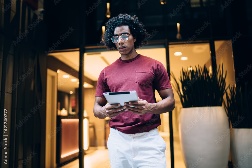 Poster puzzled hipster blogger in eyewear reading publication text installing app for wireless browsing on 