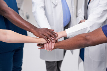 Team of diverse medical doctors putting hands together. Unity concept