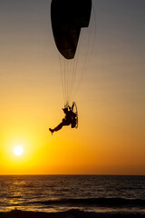 Israel, Haifa,  - March 13, 2021: paraglider flying with paramotor on air on sunset