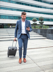 Fototapeta na wymiar Businessman with luggage on street