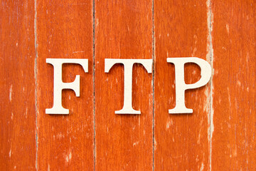 Alphabet letter in word FTP (Abbreviation of File Transfer Protocol) on old red color wood plate...