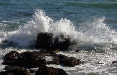 Fototapeta na wymiar A closeup photo of a wave breaking against a rock.