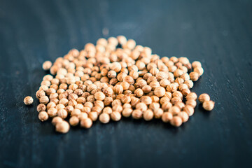 Coriander seeds on wooden support