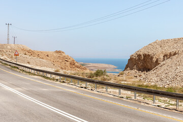 The Dead  Sea Coast is visible in the gap between the stone mountains in the stone desert in southern Israel and the mountains of Jordan are visible in the distance.